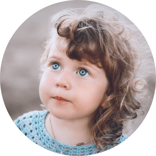 A young girl with blue eyes looking up