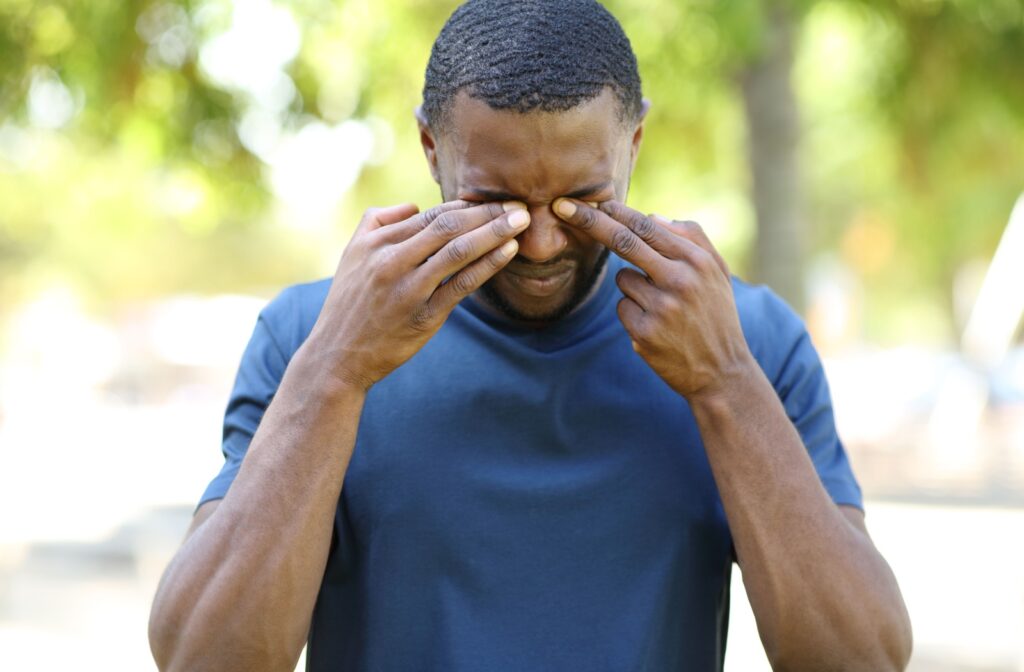 A man rubbing his eyes with his hands after wearing contact lens.