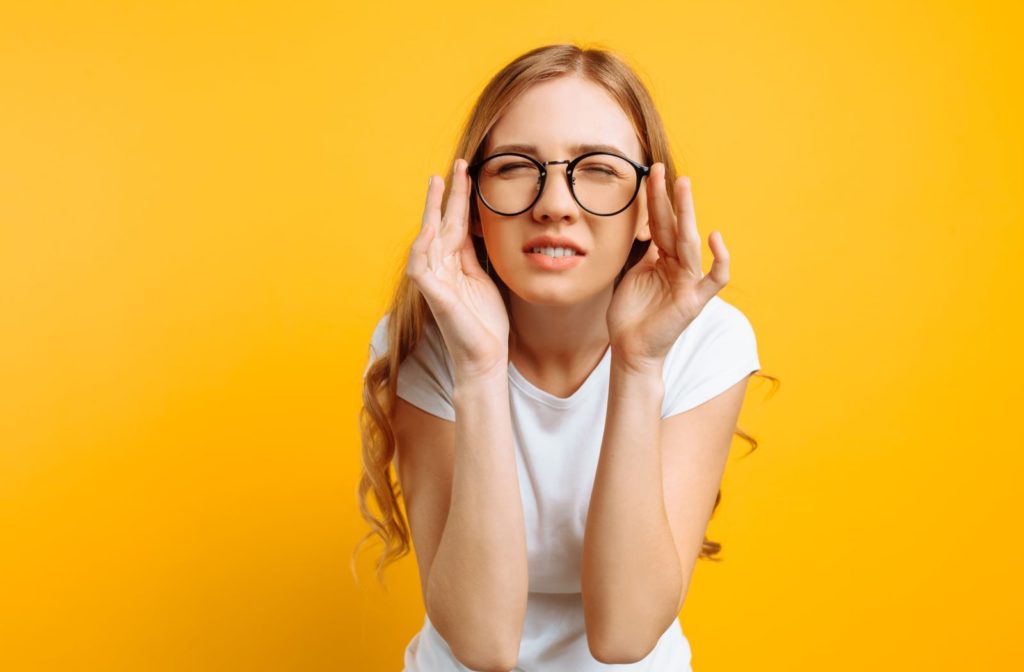 A girl in a white shirt with poor eyesight  wears glasses, squinting to see things at a far clearly