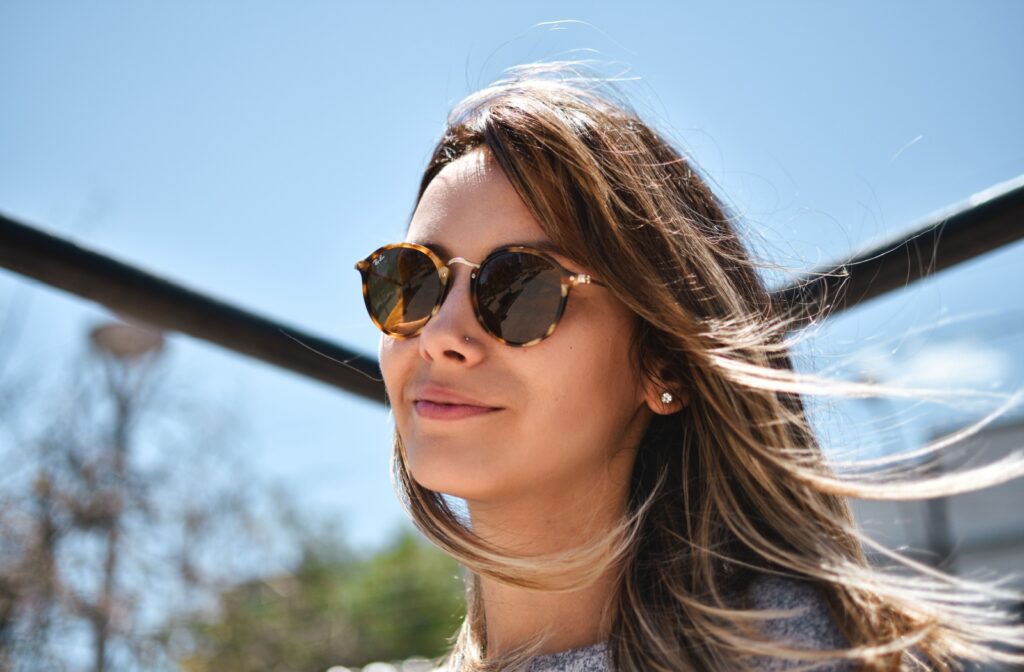 A person wearing sunglasses while outside it the sun to protect their eyes.