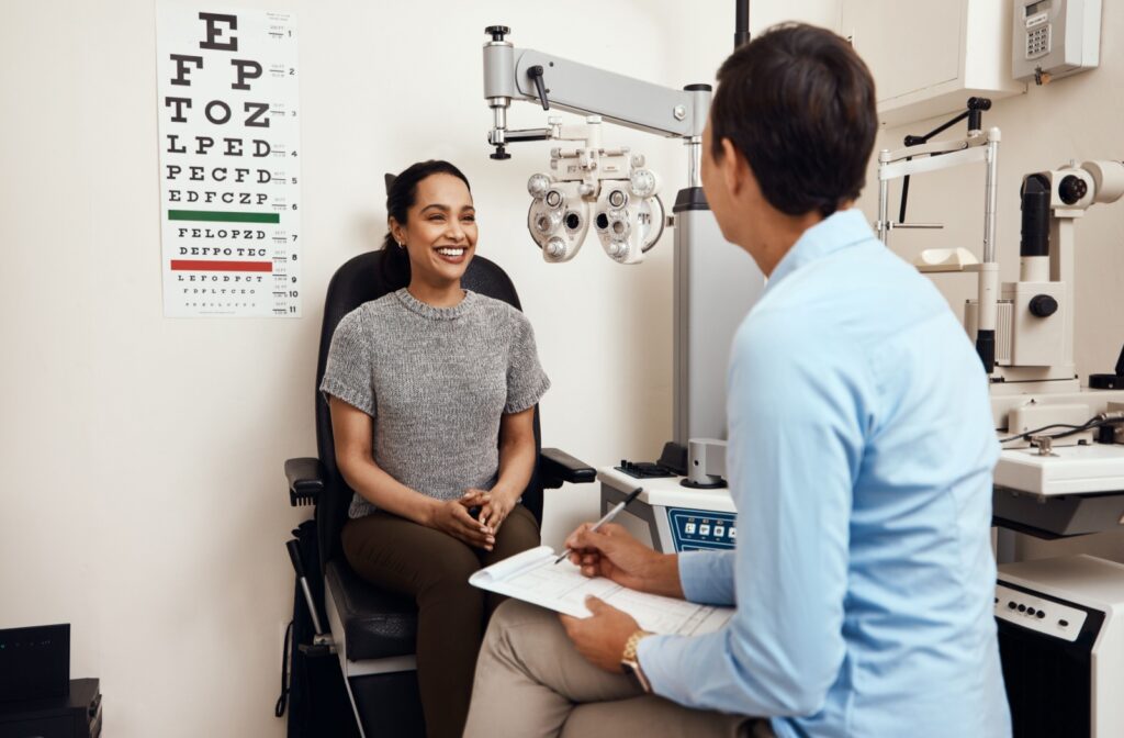 A person sits in a chair at the optometrist office while having a conversation with an eye doctor.