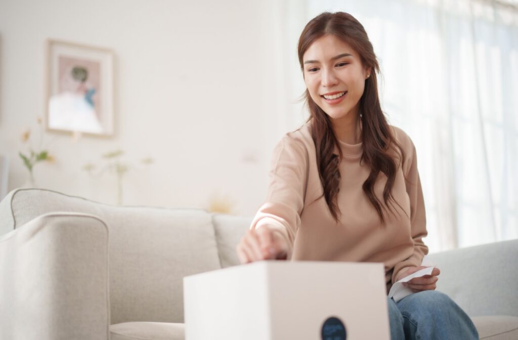 A person pressing a button to turn a white humidifer on in their living room